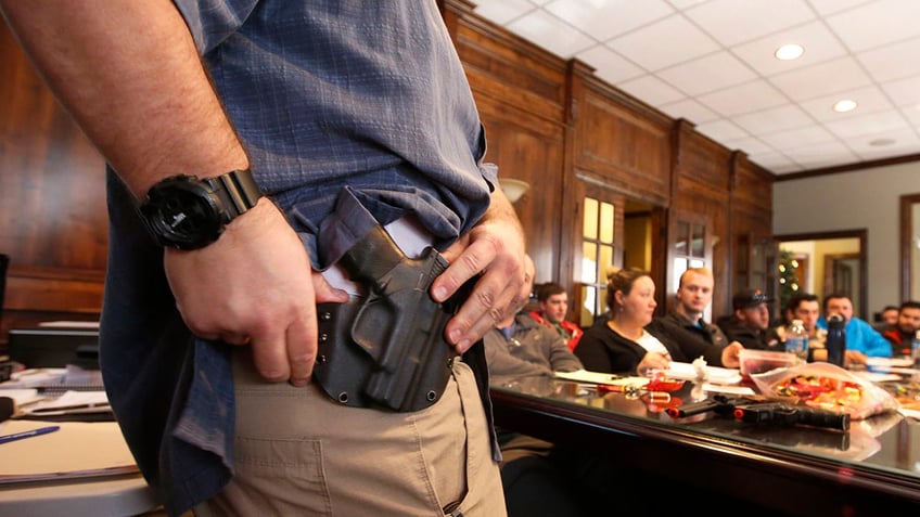 man with gun holster in front of concealed carry class