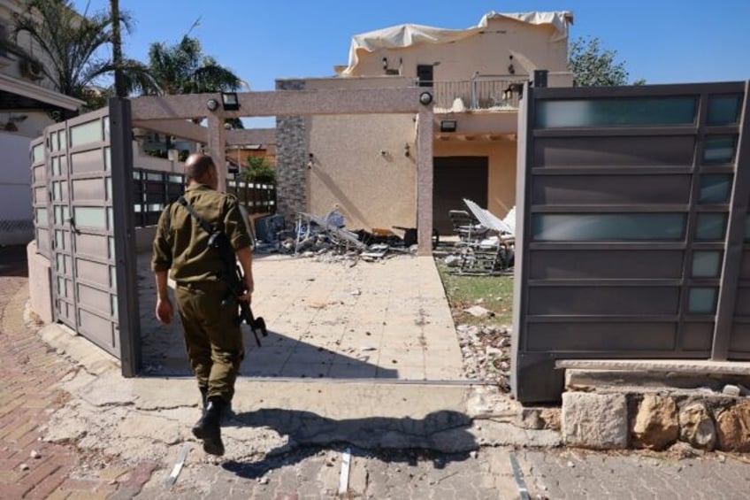 An Israeli soldier checks a house that was hit by a Hezbollah rocket in Kiryat Shmona, nor