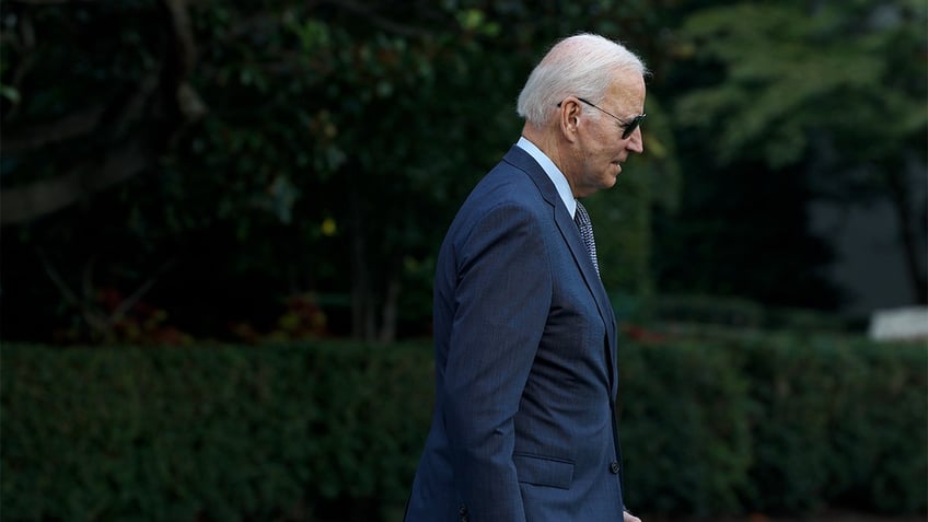 President Joe Biden with shades on walking on White House lawn