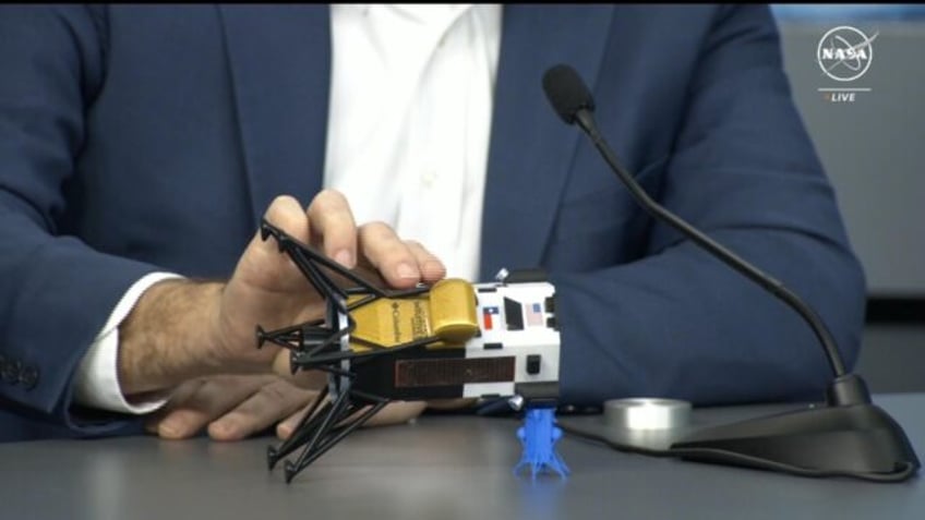 This frame grab from Nasa, shows Intuitive Machines CEO Steve Altemus holding a model of O