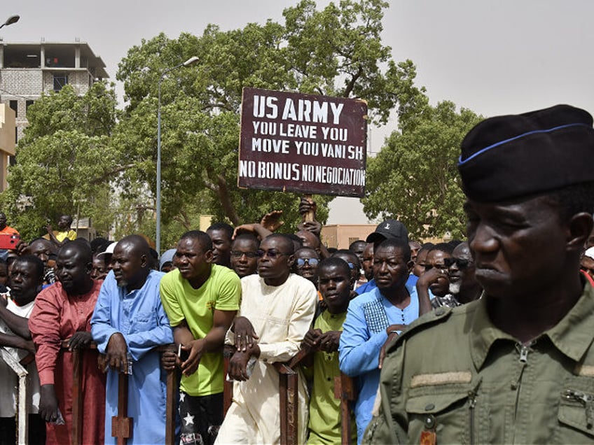 Protesters gather as a man holds up a sign demanding that soldiers from the United States