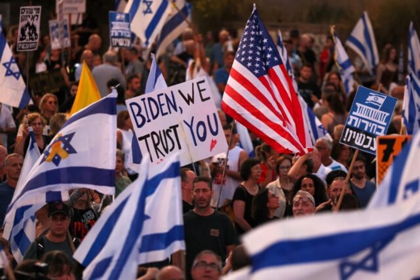 Israeli demonstrators wave the Stars and Stripes alongside the national flag as they press