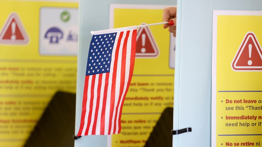 Poll worker holds American Flag