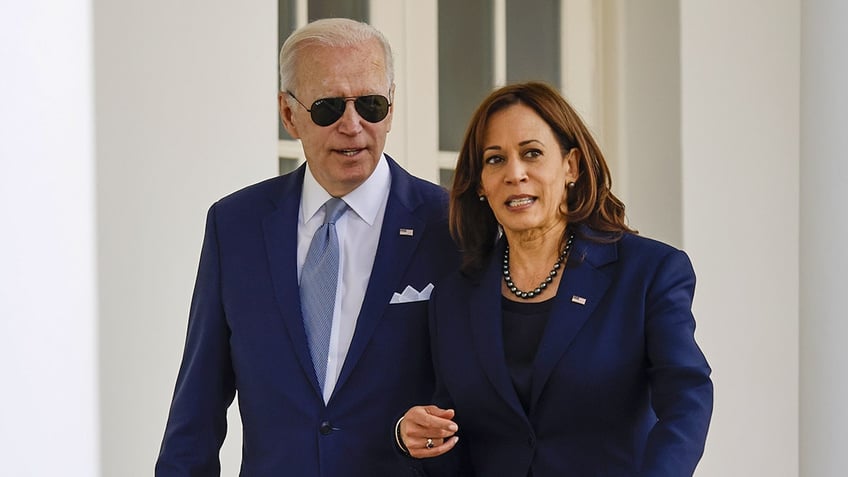 President Biden and Vice President Harris appear to be chatting as they walk through the Colonnade of the White House in Washington, D.C.