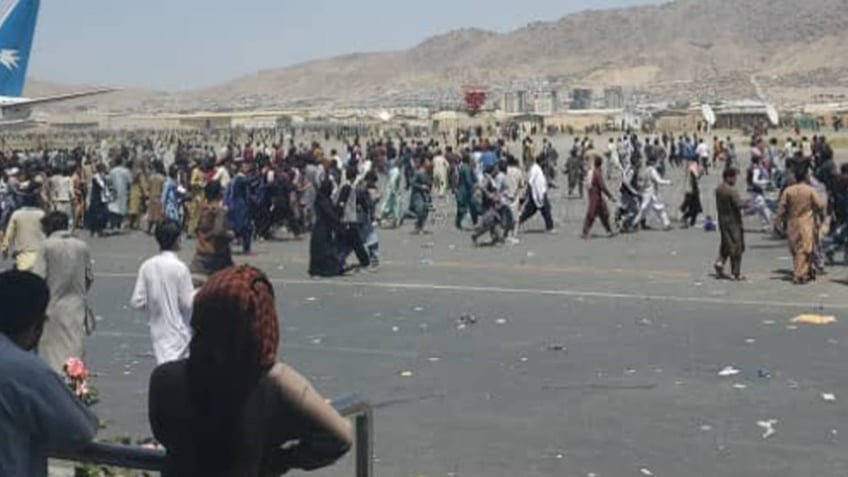 Afghans flood the tarmac of the airport