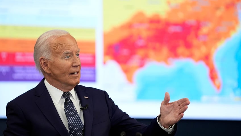 President Joe Biden gestures in front of a heat map of the United States at the D.C. Emergency Operations Center.