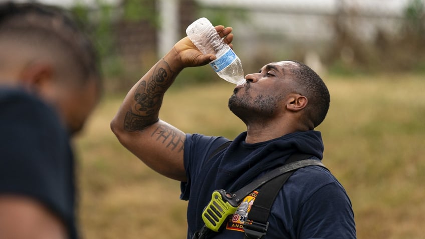 A firefighter turns a water bottle upside down as he drinks after battling a blaze in Washington, D.C.