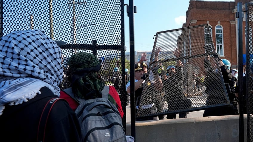 police replace fencing while facing off against demonstrators