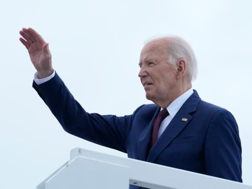 President Joe Biden waves from the top of the steps of Air Force One at Joint Base Andrews