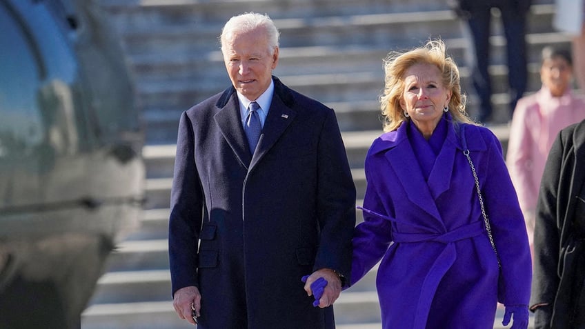 Former President Joe Biden holds his wife's hand as the two leave D.C. following President Donald Trump's inauguration