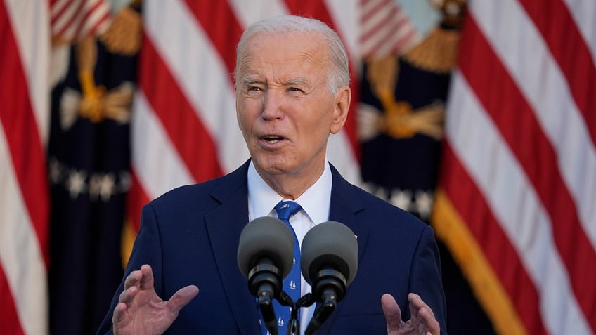 Biden in Rose Garden appearance with flags behind him 