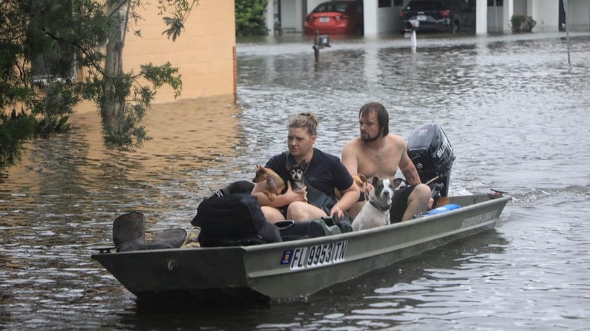 Residents and their pets evacuate Magnolia Avenue after Hurricane Milton flooded the neighbourhood in South Daytona