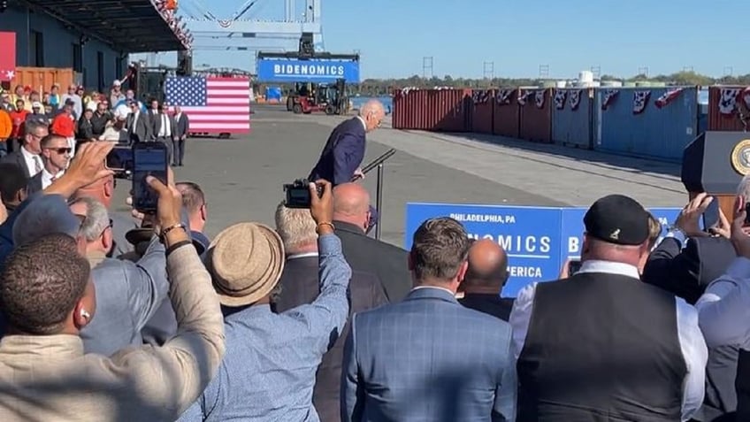 biden trips in philadelphia while climbing steps to podium on stage video