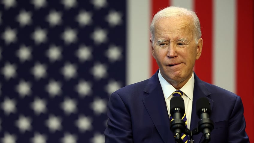 President Joe Biden standing in front of an American flag