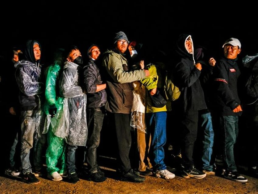 Jacumba, CA, Friday, November 24, 2023 - Chinese migrants huddle in a line to receive colo