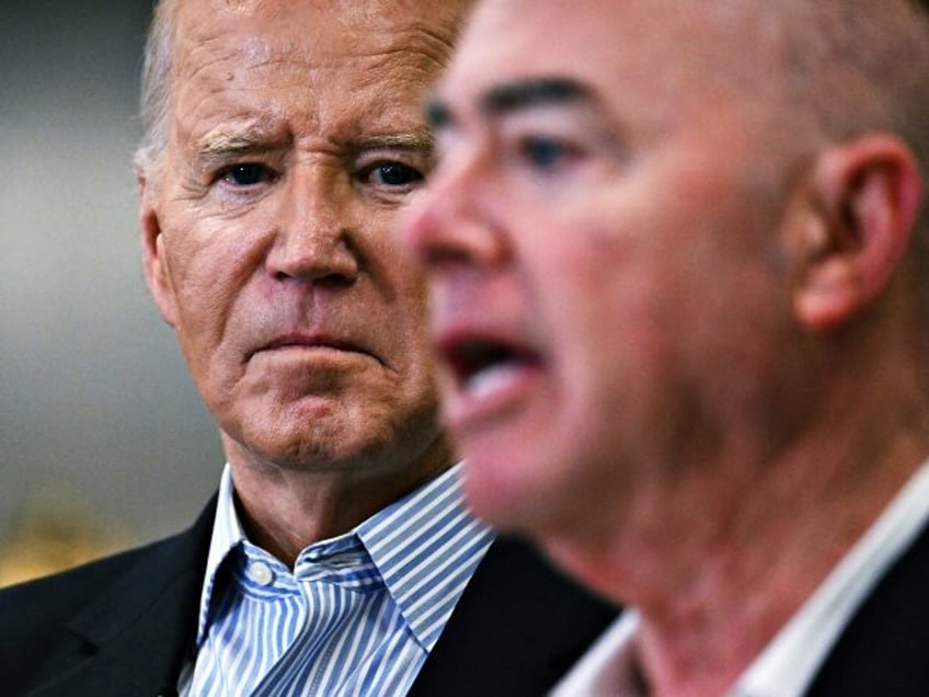 US President Joe Biden (L) listens as Homeland Security Secretary Alejandro Mayorkas speak