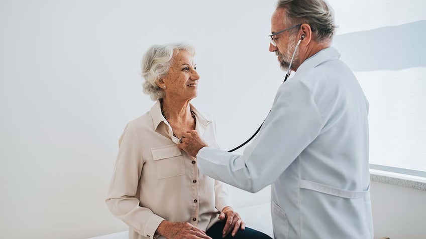 woman gets heart checked by doctor