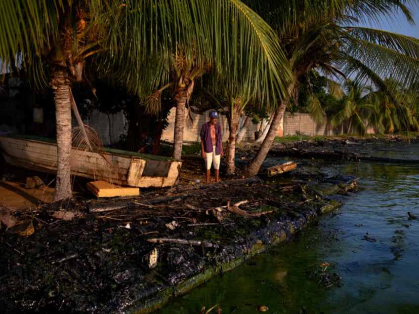 A fisherman on the oil-covered shore of Lake Maracaibo in El Bajo, Zulia state, Venezuela on Saturday, Nov. 18, 2023. A decision by the US on Oct. 18 to ease sanctions in exchange for greater political freedom in Venezuela, has opened the doors for dealmaking and increased production that will enable the Latin American country's crude to reach global markets. Photographer: Gaby Oraa/Bloomberg via Getty Images