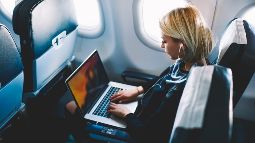 Woman using laptop aboard plane