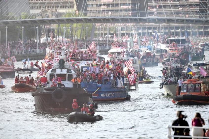 Athletic Bilbao players sail on board the famous "Gabarra" boat (C) under the Zubizuri bri