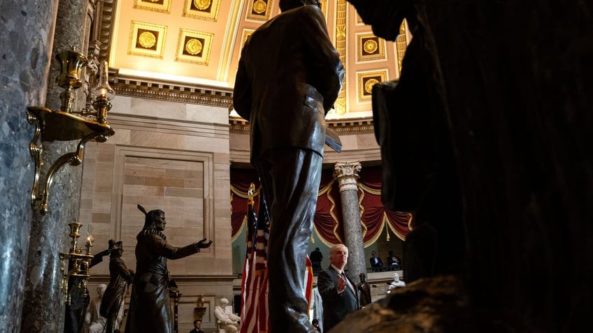 Rev. William Franklin Graham III gestures to the statue of his late father as he speaks