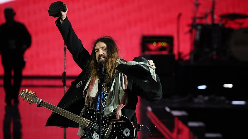 Billy Ray Cyrus lifts up his hand in the air while performing at the LIberty Ball