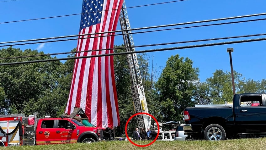 A photo of Billy Ray Cyrus standing with law enforcement outside Corey Comperatore's funeral