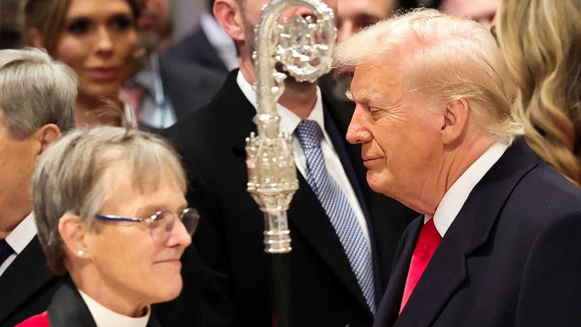 Donald Trump stands near Reverend Mariann Edgar Budde