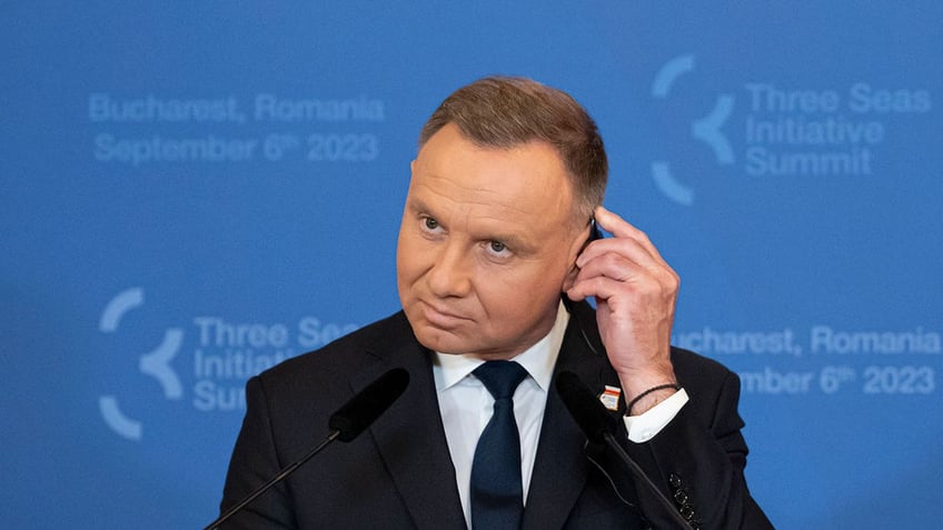 Andrzej Duda adjusts headphones