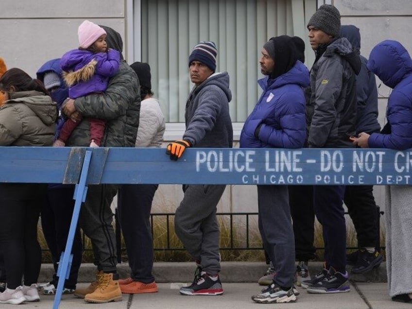 Migrants stand in line to receive food from the nonprofit Chi-Care Thursday, Jan. 11, 2024