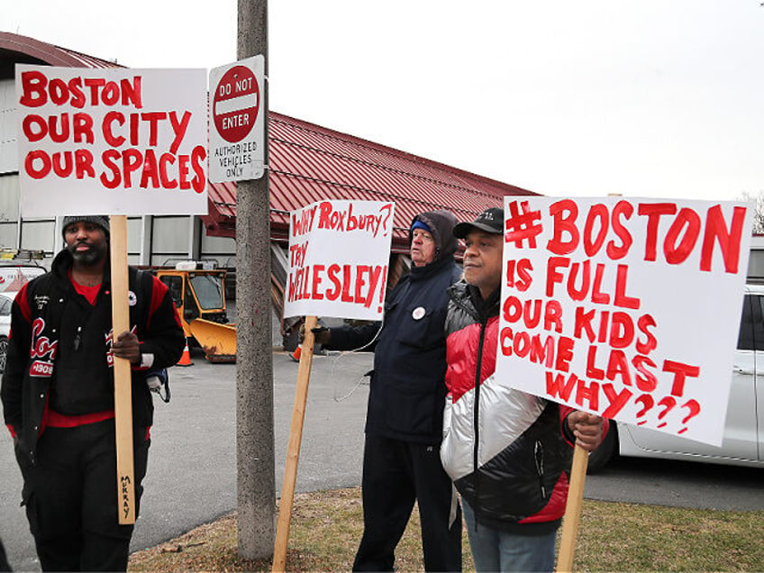 Boston, MA - January 31: Protesters hold signs outside as State and local officials toured the Melnea A. Cass Recreational Complex. The facility will be housing over 300 migrants. (Photo by John Tlumacki/The Boston Globe via Getty Images)