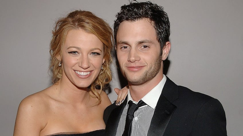 Blake Lively wraps her arm around actor Penn Badgley