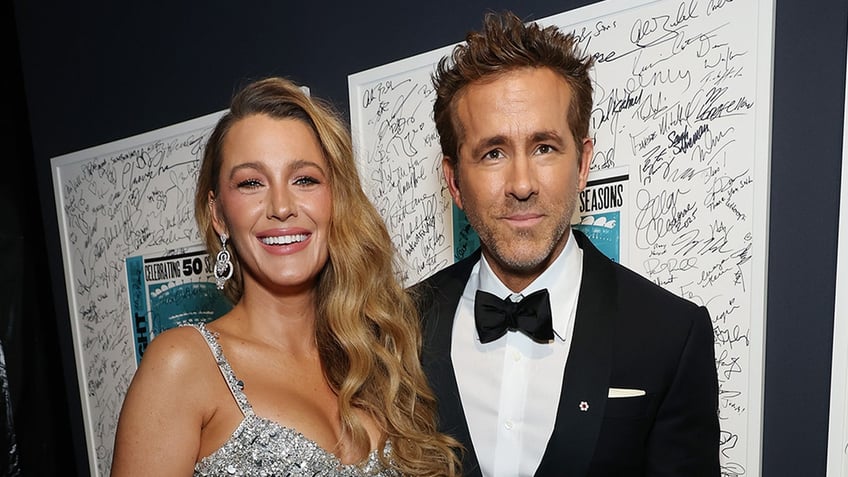 Bake Lively smiles in sparkling silver dress next to husband Ryan Reynolds.