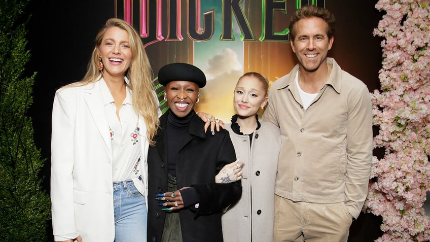 Blake Lively smiles next to Ryan Reynolds, Ariana Grande and Cynthia Erivo at Wicked premiere.