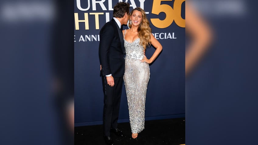 Ryan Reynolds leans over to whisper in Blake Lively's ear.