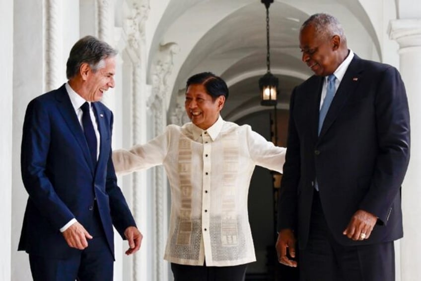 Philippines' President Ferdinand Marcos Jr. (C) greets US Secretary of State Antony Blinke