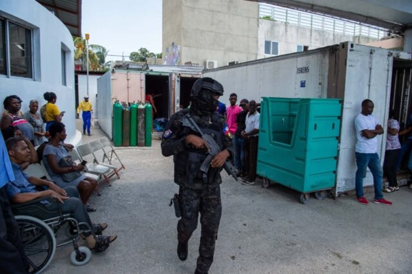 A police officer patrols during a visit of Haitian Prime Minister Garry Conille at Hospita