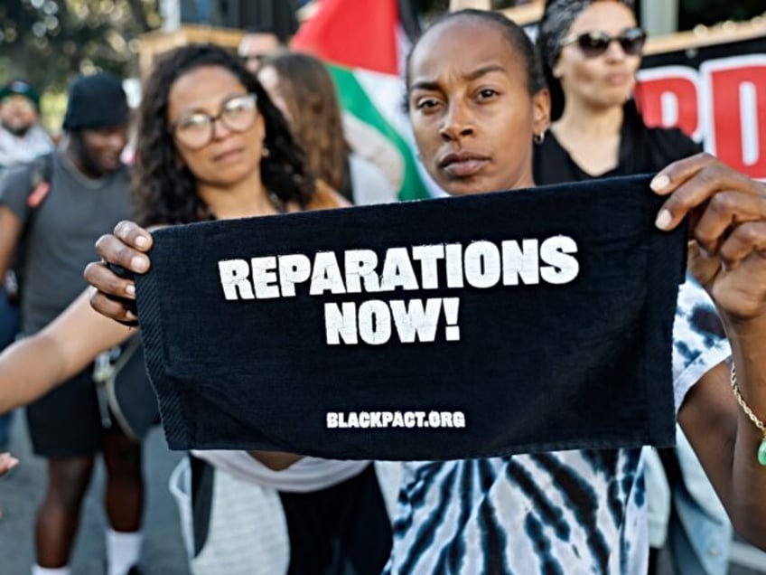 LOS ANGELES, CALIFORNIA - MAY 21: A protestor displays sign reading "Reparations Now!" dur