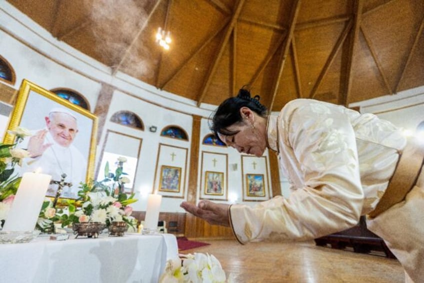 A woman attends a memorial mass to pay tribute to the late Pope Francis at Saints Peter an