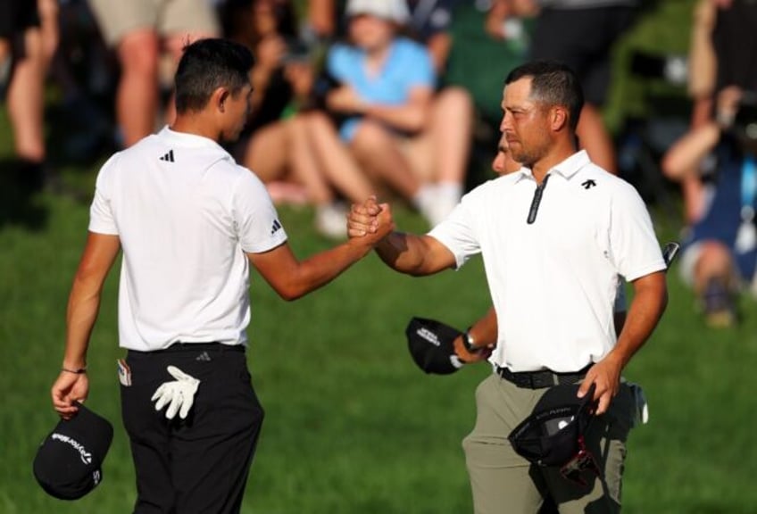 Americans Collin Morikawa, left, and Xander Schauffele shake hands on the 18th green at Va