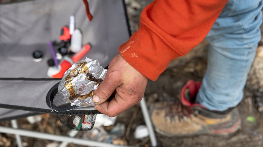 Homeless man holds stained foil used for fentanyl