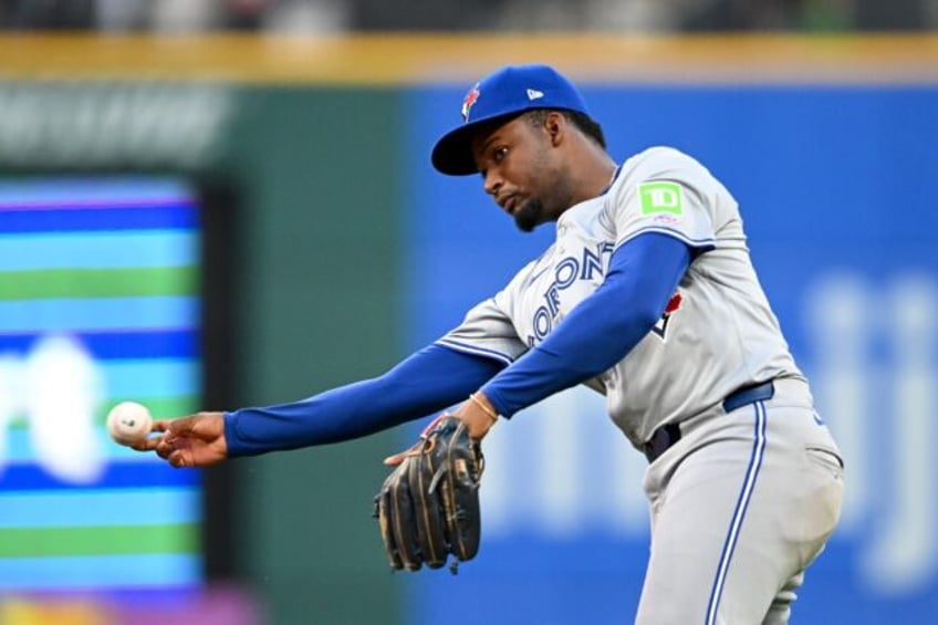 Orelvis Martinez of the Toronto Blue Jays throws out Will Brennan of the Cleveland Guardia