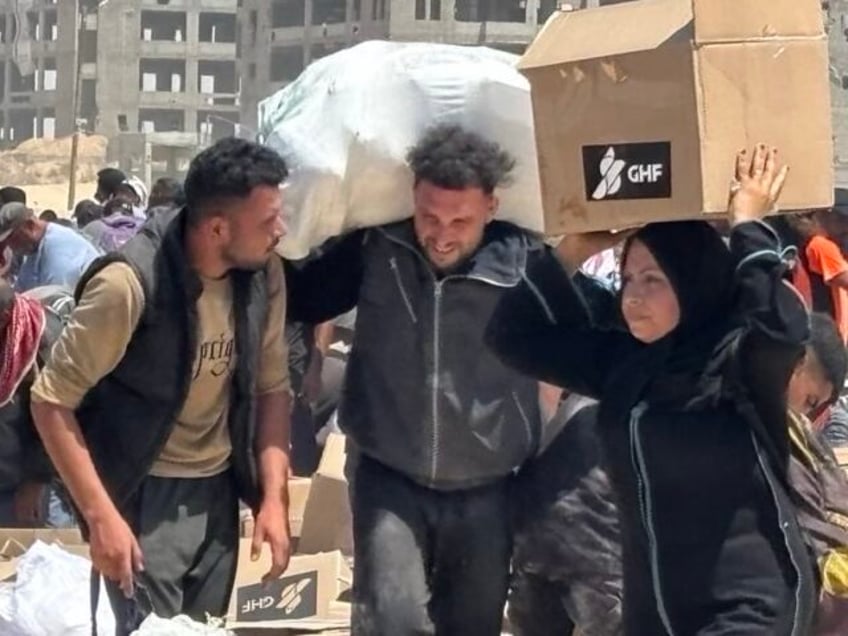 Palestinians collect aid boxes at an aid site run by the U.S.-backed Gaza Humanitarian Fou
