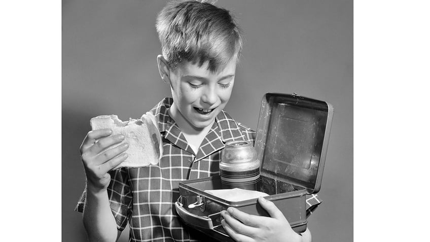 Boy with sandwich and lunch box.