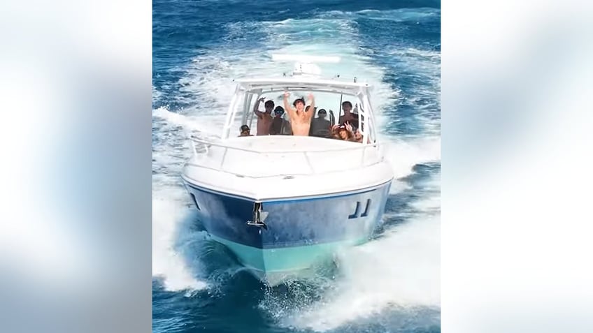 Boca Bash party goers wave to the drone camera after dumping garbage in the Atlantic.