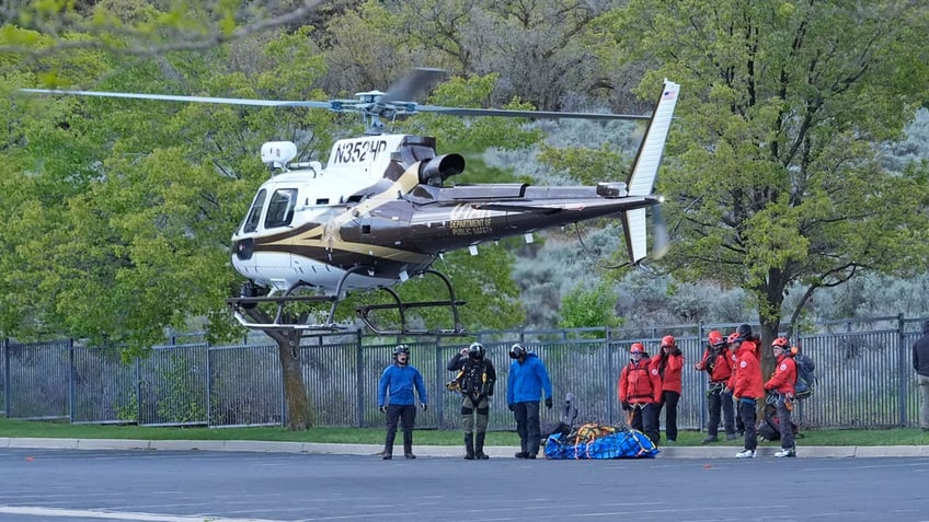 A helicopter lands in a staging area while recovery efforts continue for two skiers who died in backcountry avalanche in Utah.