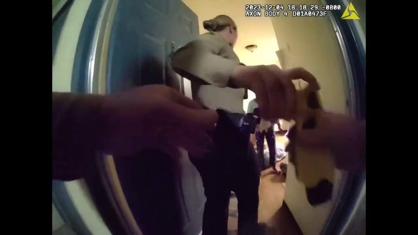 Deputy Ty Shelton is handed a Taser by another deputy