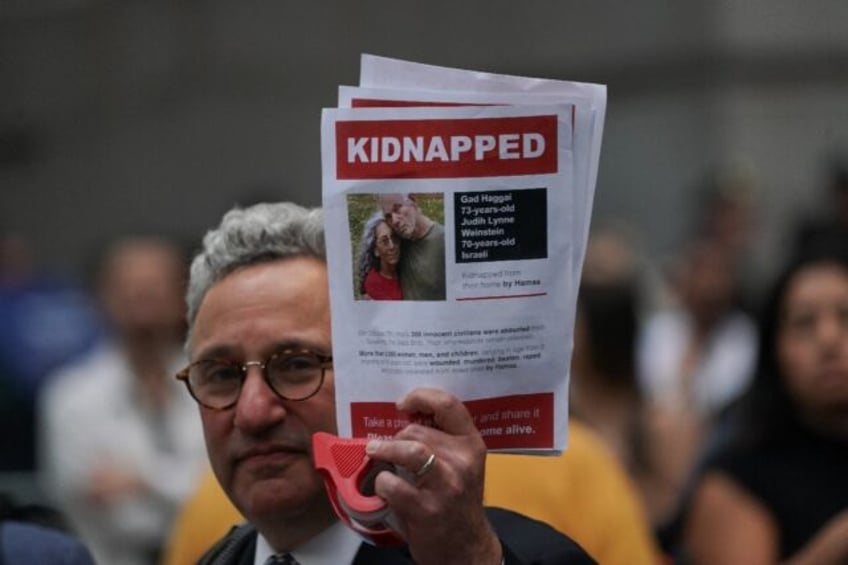 A man holds a picture of hostages Gad and Judith Weinstein Haggai -- both of whom have been confirmed killed -- during a New York rally on October 26, 2023