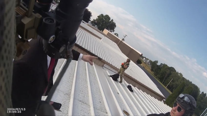 Beaver County Emergency Services officers and a Secret Service agent exchange information on the roof of the building where Thomas Crooks took shots at former President Trump.