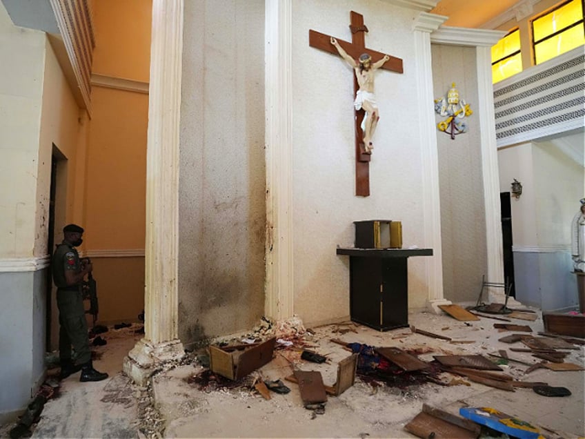 A police officer stands guard inside the St. Francis Catholic Church, a day after an attack that targeted worshipers in Owo, Nigeria, Monday, June 6, 2022. The gunmen who killed 50 people at a Catholic church in southwestern Nigeria opened fire on worshippers both inside and outside the building in a coordinated attack before escaping the scene, authorities and witnesses said Monday. (AP Photo/Sunday Alamba)